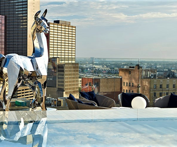 a statue of a llama on a rooftop overlooking a city