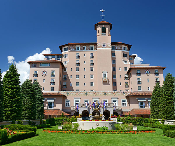 a large building with a fountain in front of it with The Broadmoor in the background