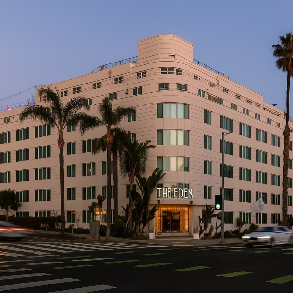 a building with palm trees and cars on the street