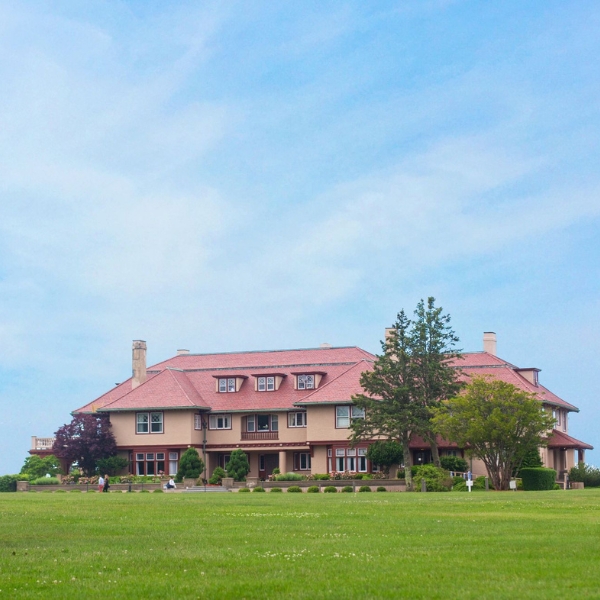 a large house with a lawn and trees