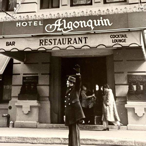 a man in uniform waving in front of a restaurant