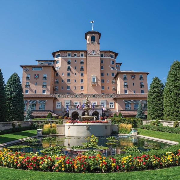 a large building with a fountain in front of it with The Broadmoor in the background