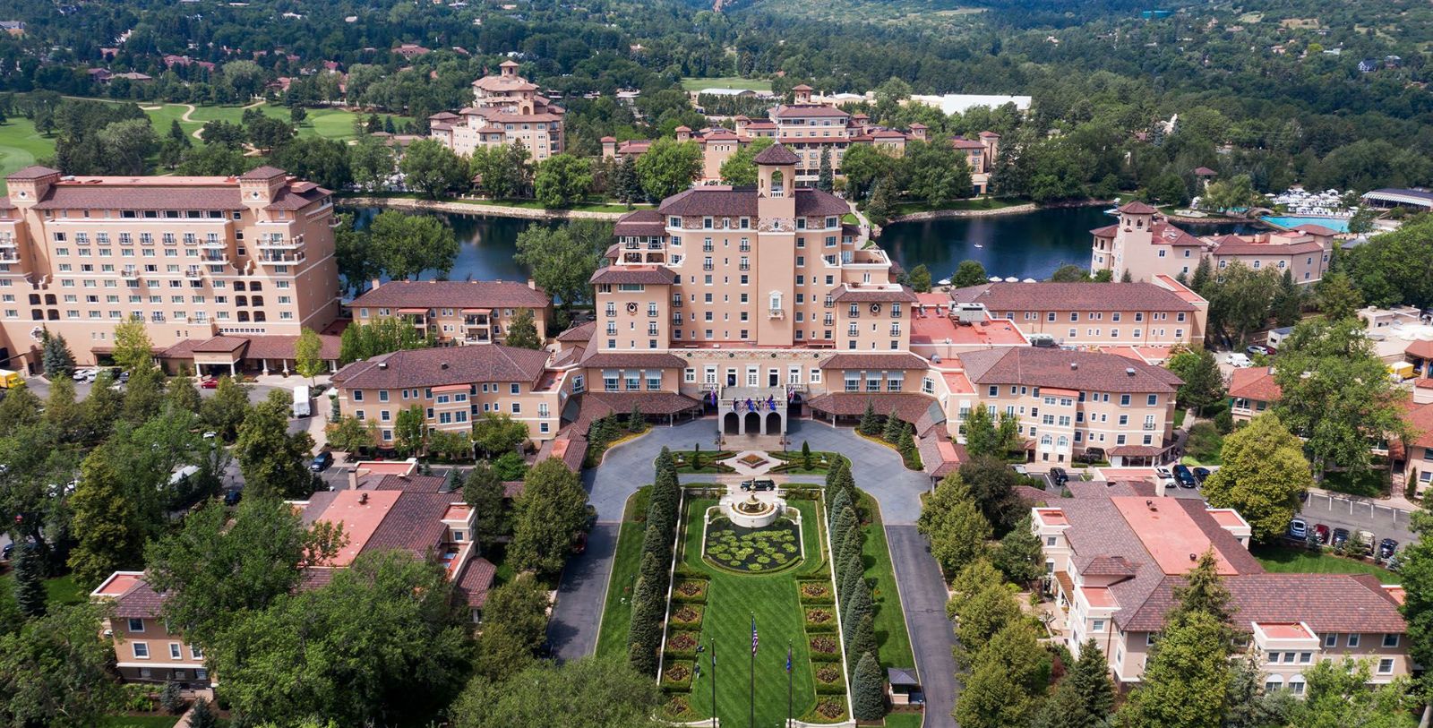 a large building with a pond and trees