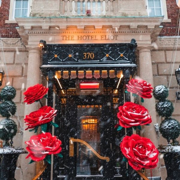 a building with red flowers and snow falling