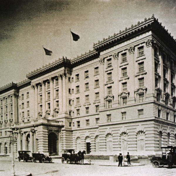 a large building with a horse carriage and people