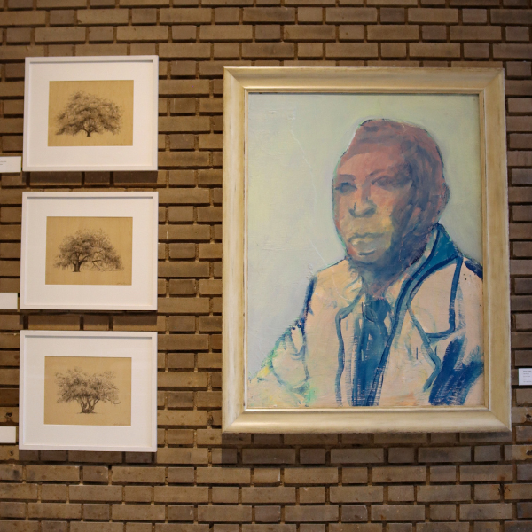 a framed picture of a man on a brick wall