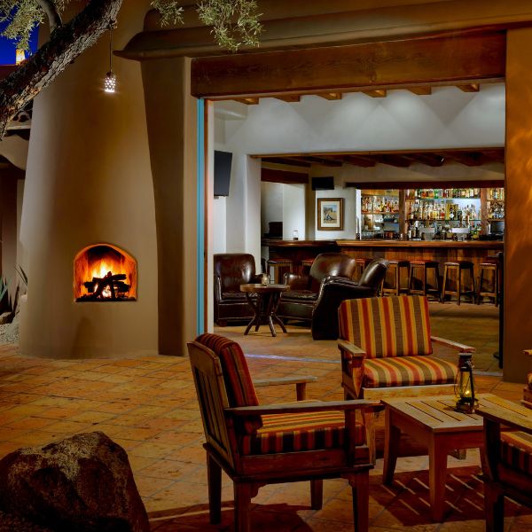 a patio with chairs and a fireplace