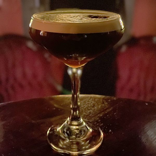 a glass with a drink on a table