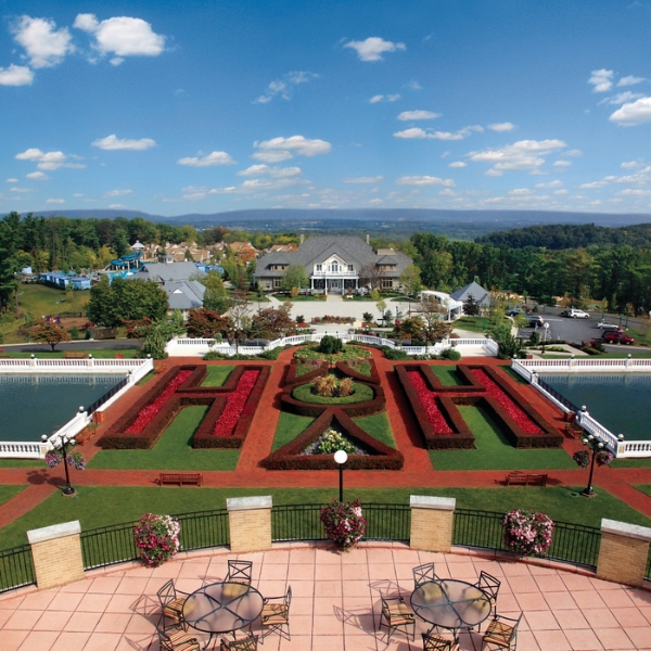 a view of a garden with a pool and a house in the background