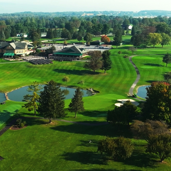 a golf course with a building and water