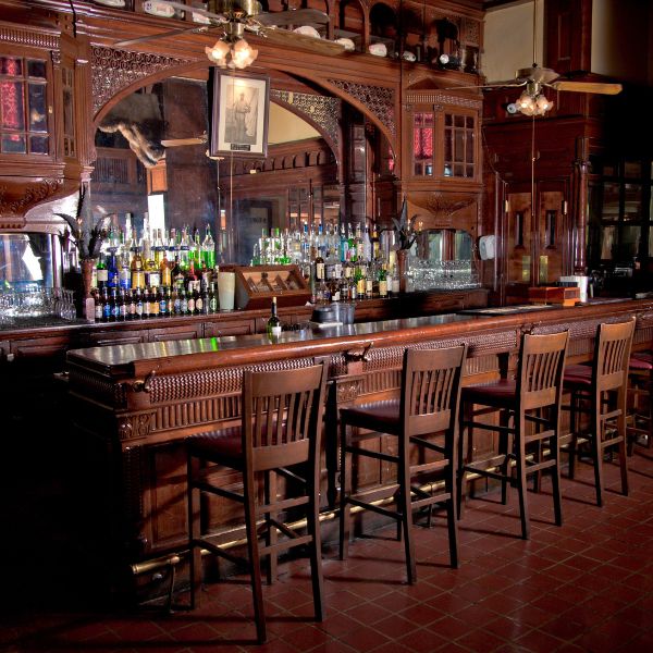 a bar with a row of chairs and a mirror
