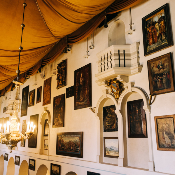 a wall with pictures and a chandelier