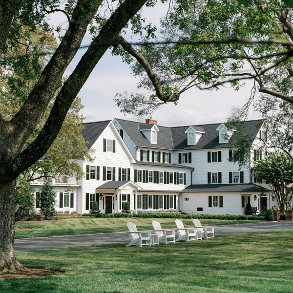 a large white house with lawn and lawn chairs