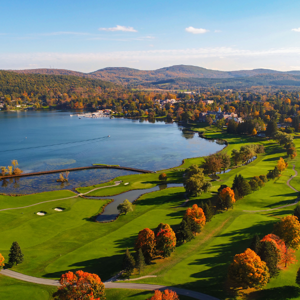 a golf course with a body of water and trees