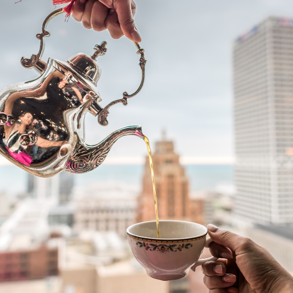 a person pouring tea into a cup