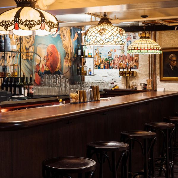 a bar with stools and lights