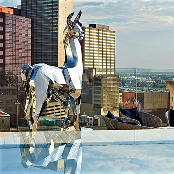 a statue of a llama on a rooftop overlooking a city