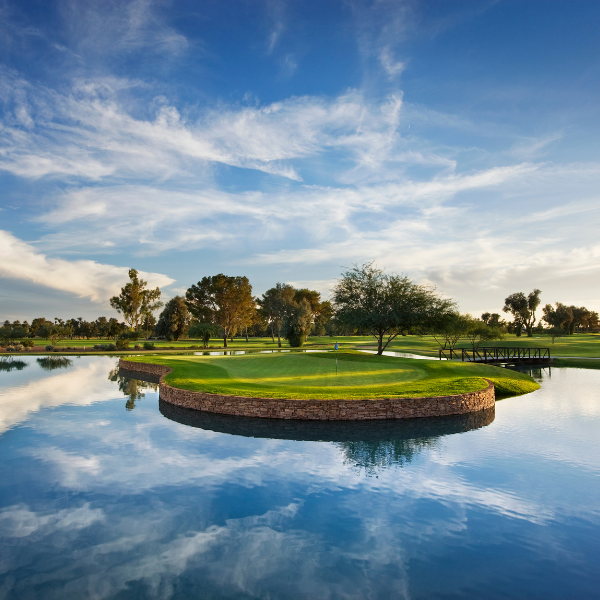 a golf course with a body of water and a small island