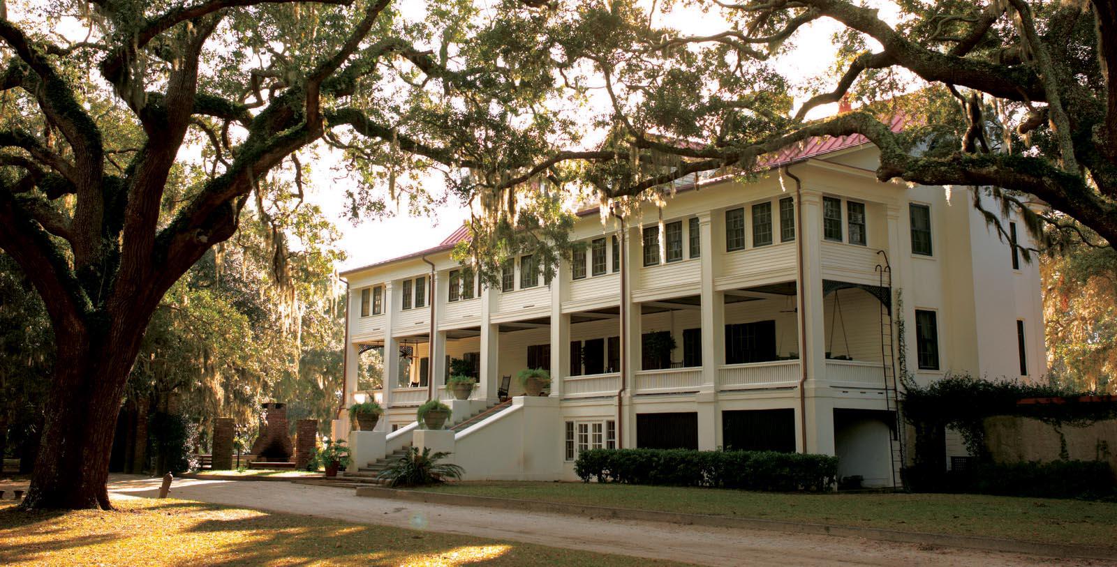 a large white building with trees and grass 10