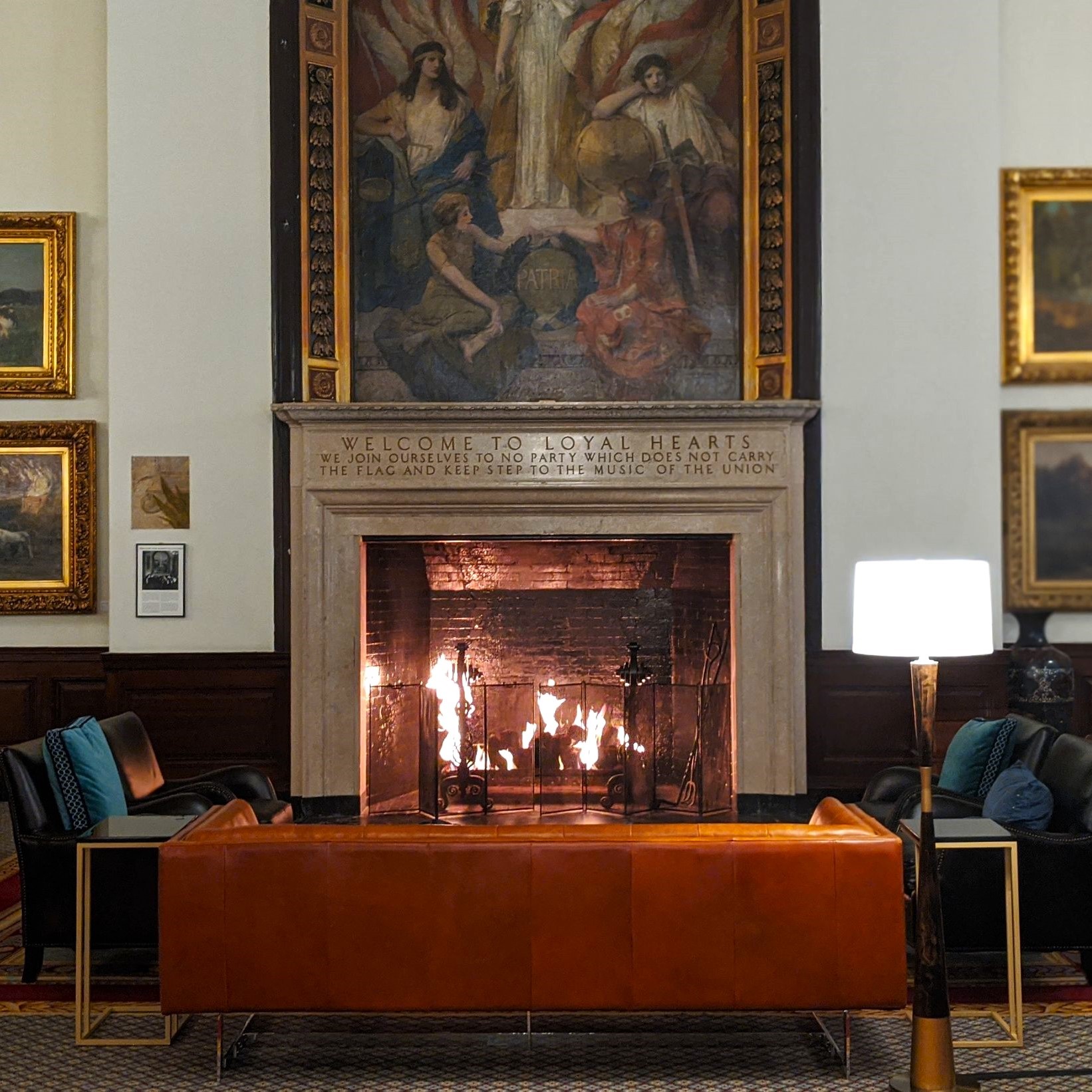 a fireplace in a room with paintings on the wall
