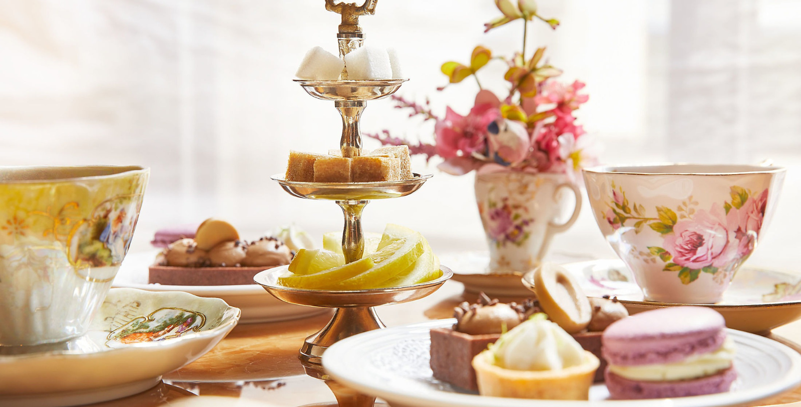 a tiered dessert stand with fruit slices and a cup of tea