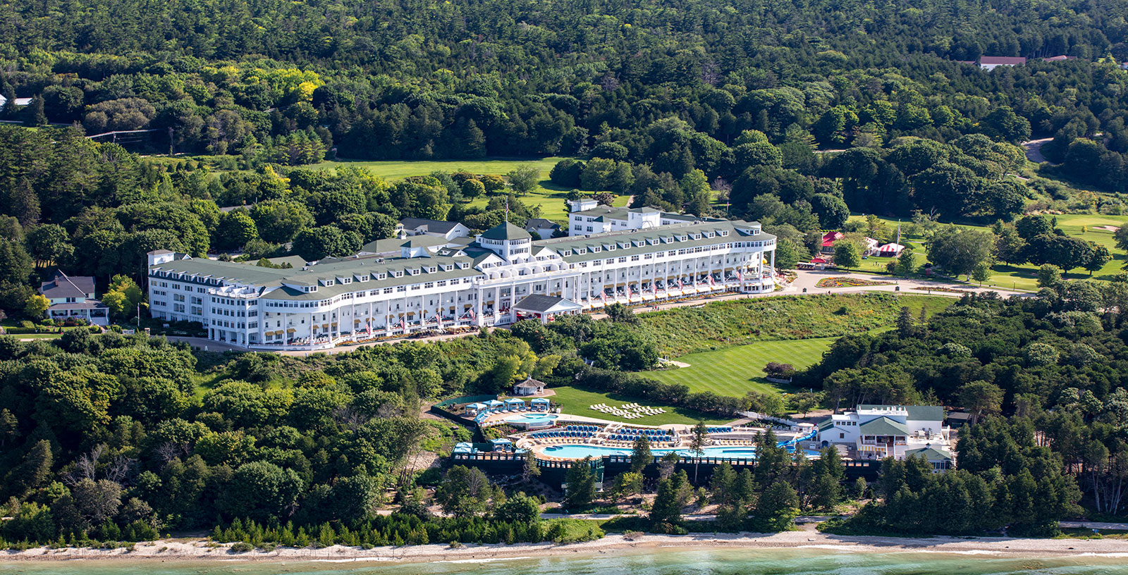 a large white building with a pool in front of it