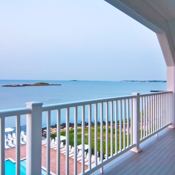 a deck with a white railing overlooking the ocean