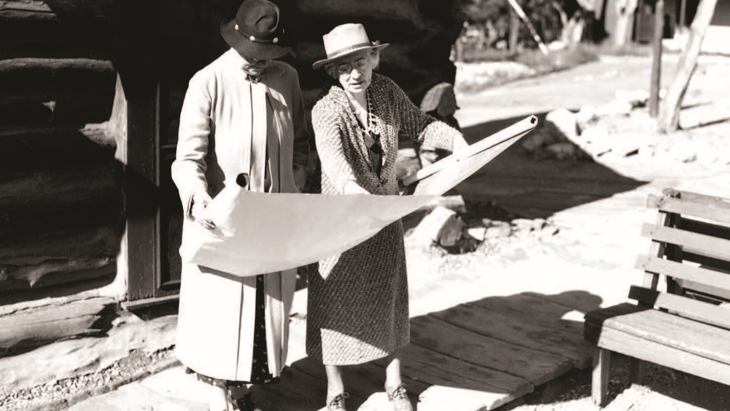 a couple of women looking at a piece of paper