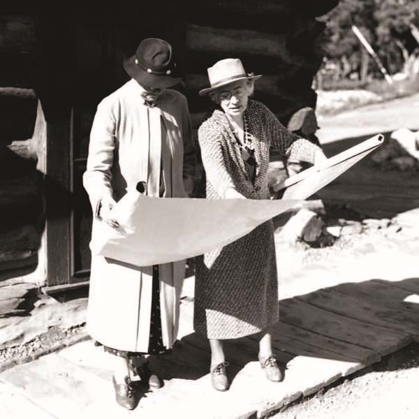 a couple of women looking at a map
