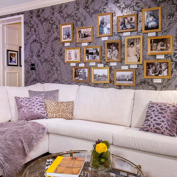 a couch with pillows and a coffee table with pictures on the wall