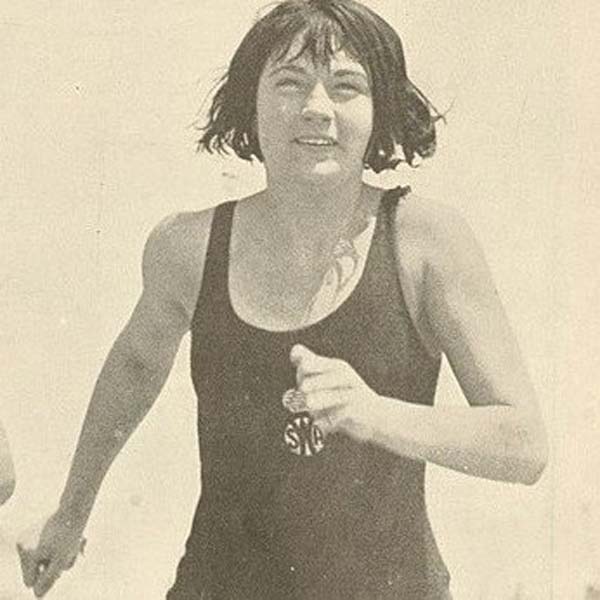 a woman running with a man in a swimsuit