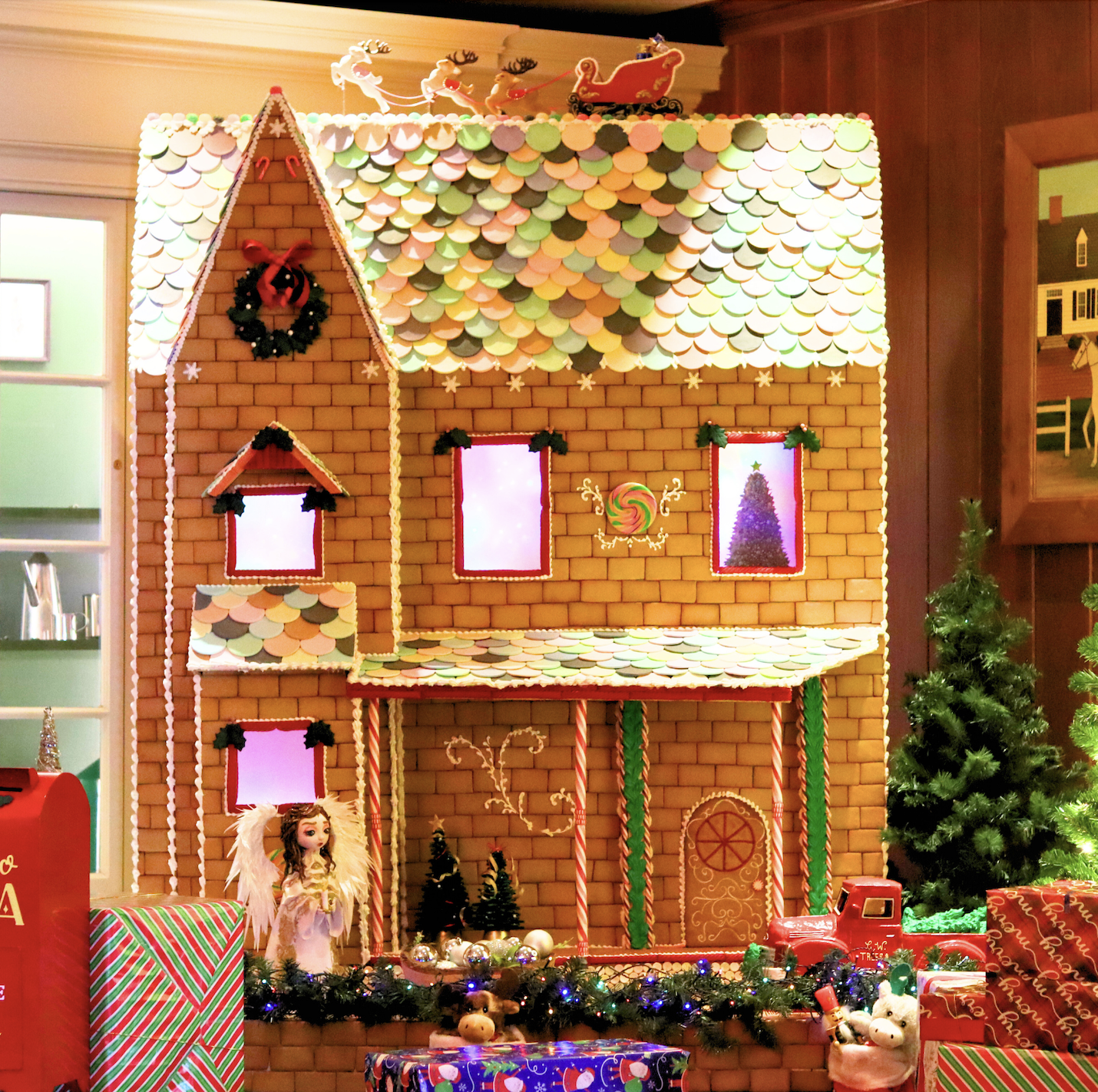 a gingerbread house with presents and a tree