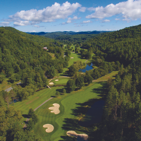 a golf course with a lake and trees