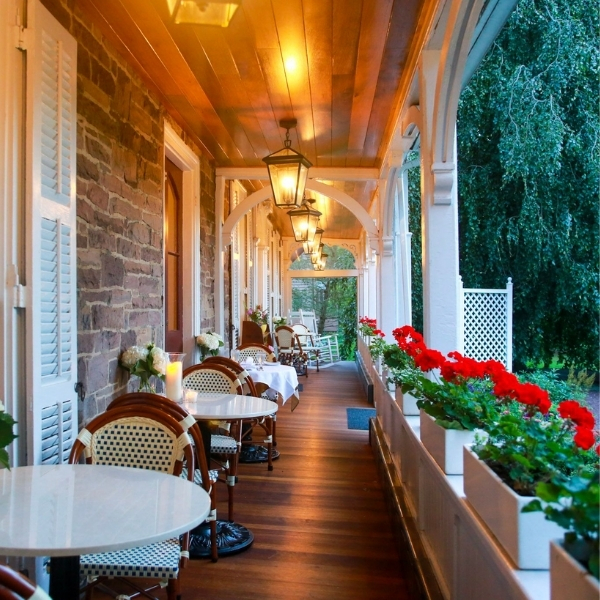 a porch with tables and chairs
