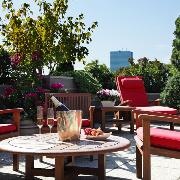 a patio with chairs and a table with a champagne bottle