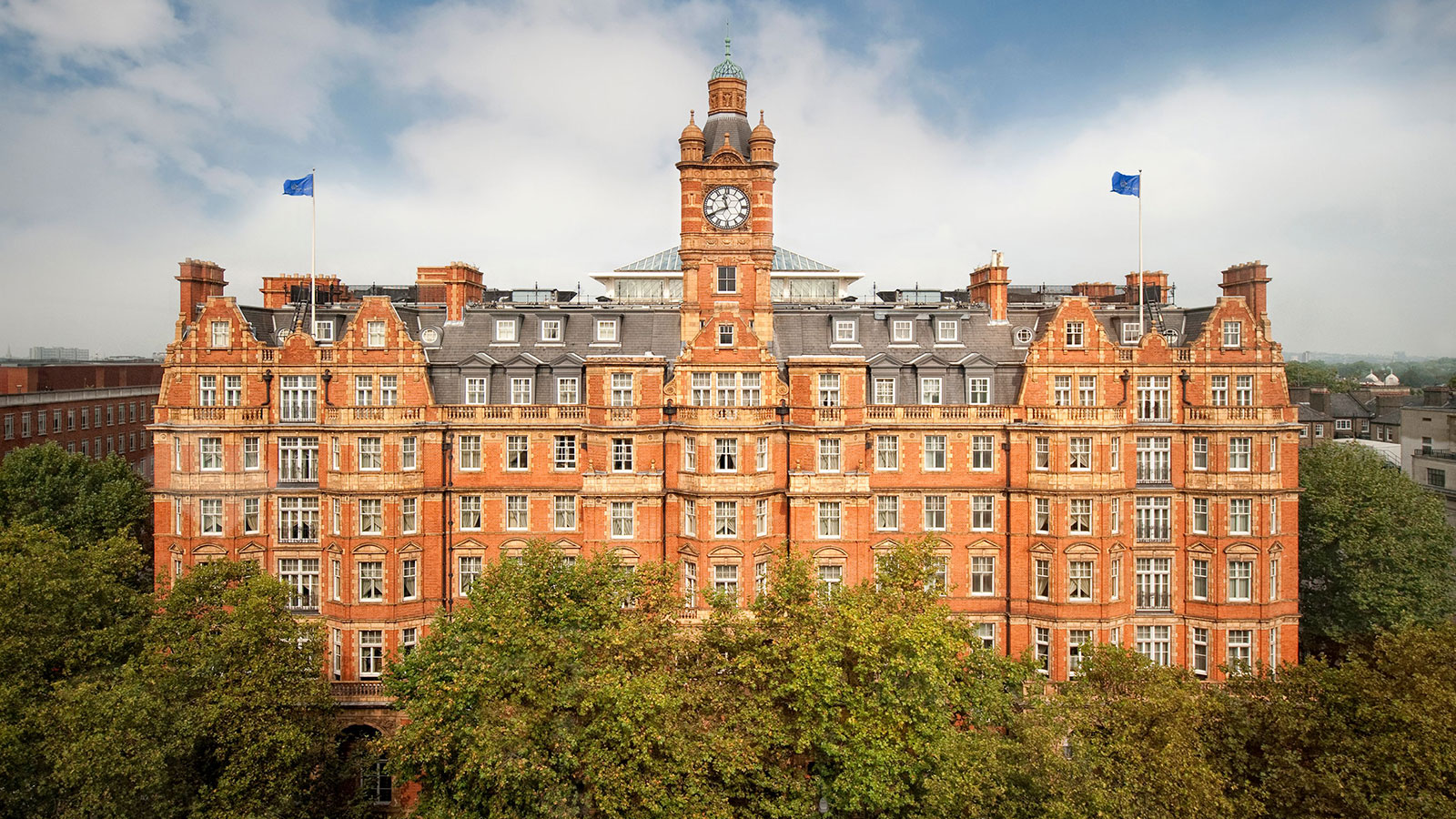 a large brick building with a clock tower and trees 16