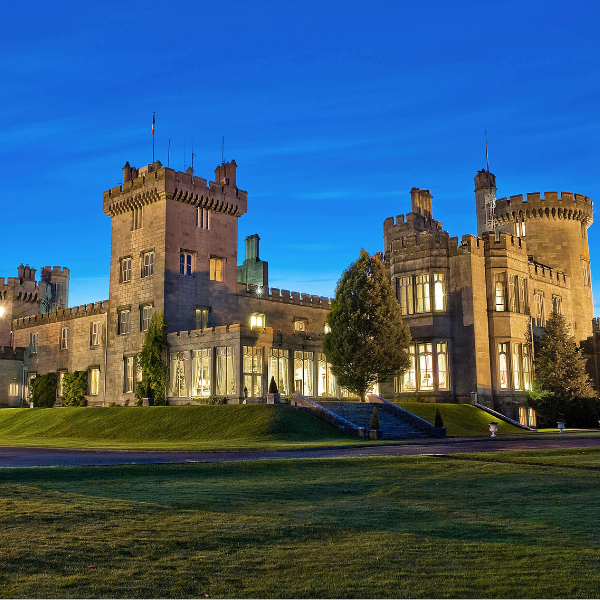 a large stone castle with a lawn and trees