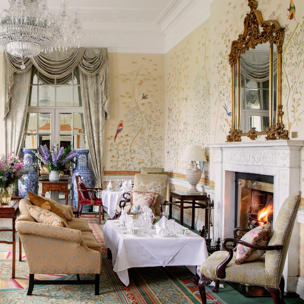 a room with a fireplace and a table with chairs and a chandelier