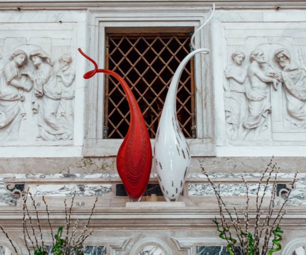 a red and white sculpture on a window sill