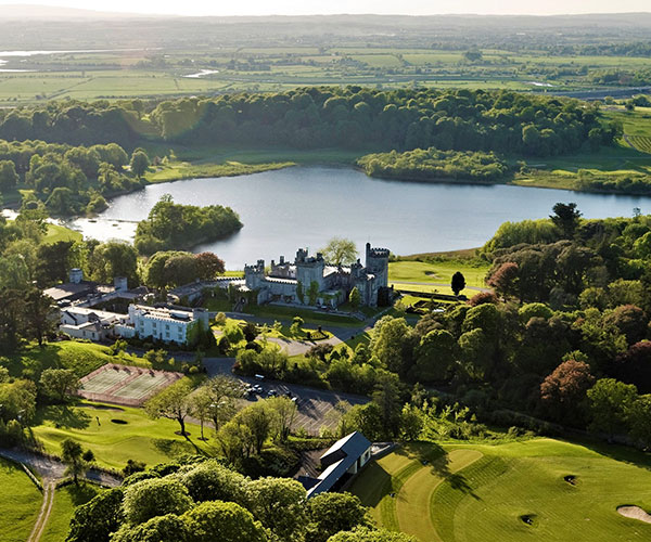 a castle surrounded by trees and a lake