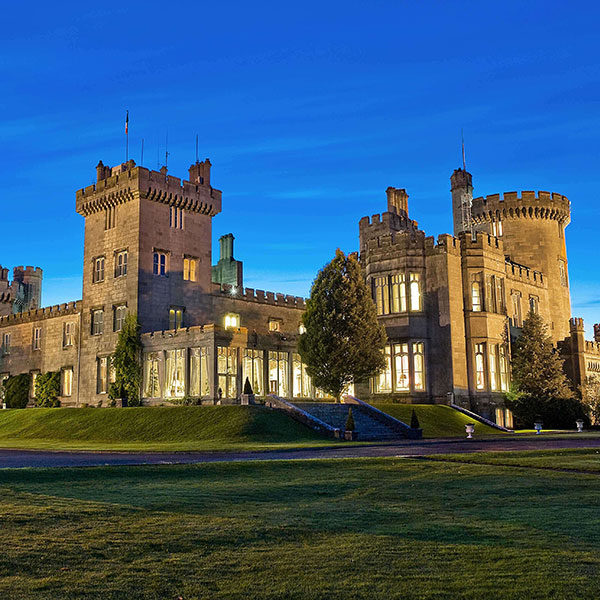 a large stone castle with many windows and a lawn