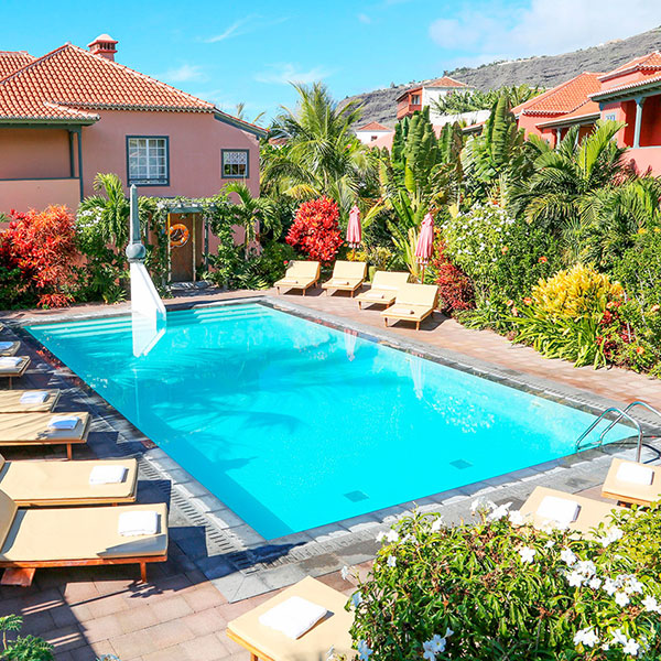 a pool with lounge chairs and a building in the background