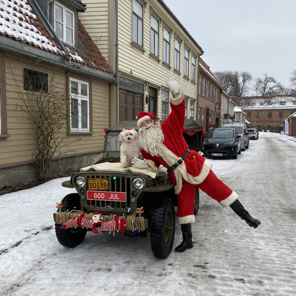 a man in a garment and a dog on a car