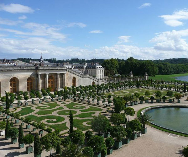 a large garden with a pond and a building
