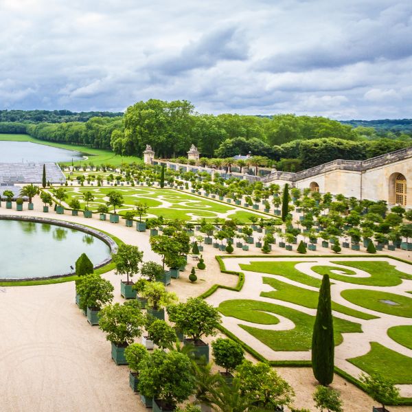 a large garden with a body of water and a bridge