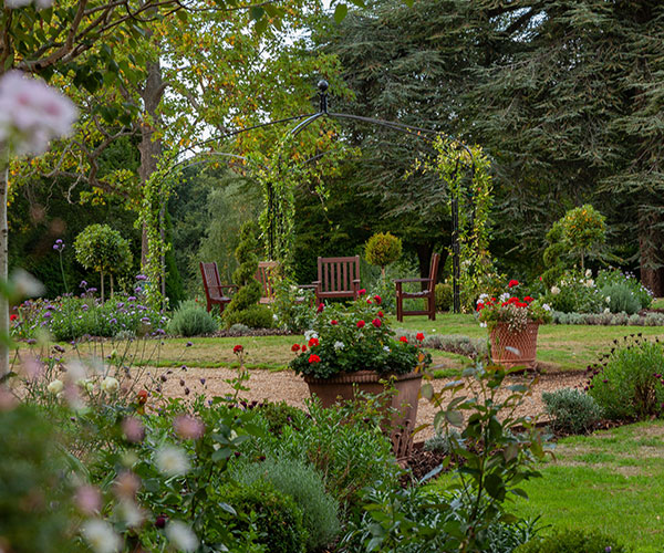a garden with chairs and a table