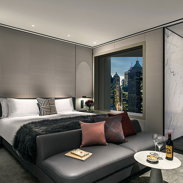 a bed with a couch and wine in a room with a window