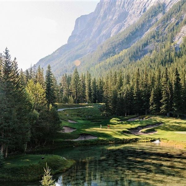 a golf course with a lake and trees