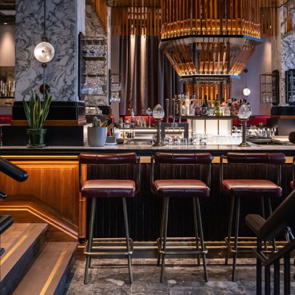 a bar with chairs and a chandelier