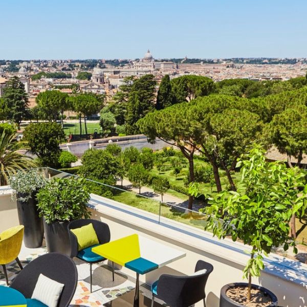 a rooftop patio with trees and chairs
